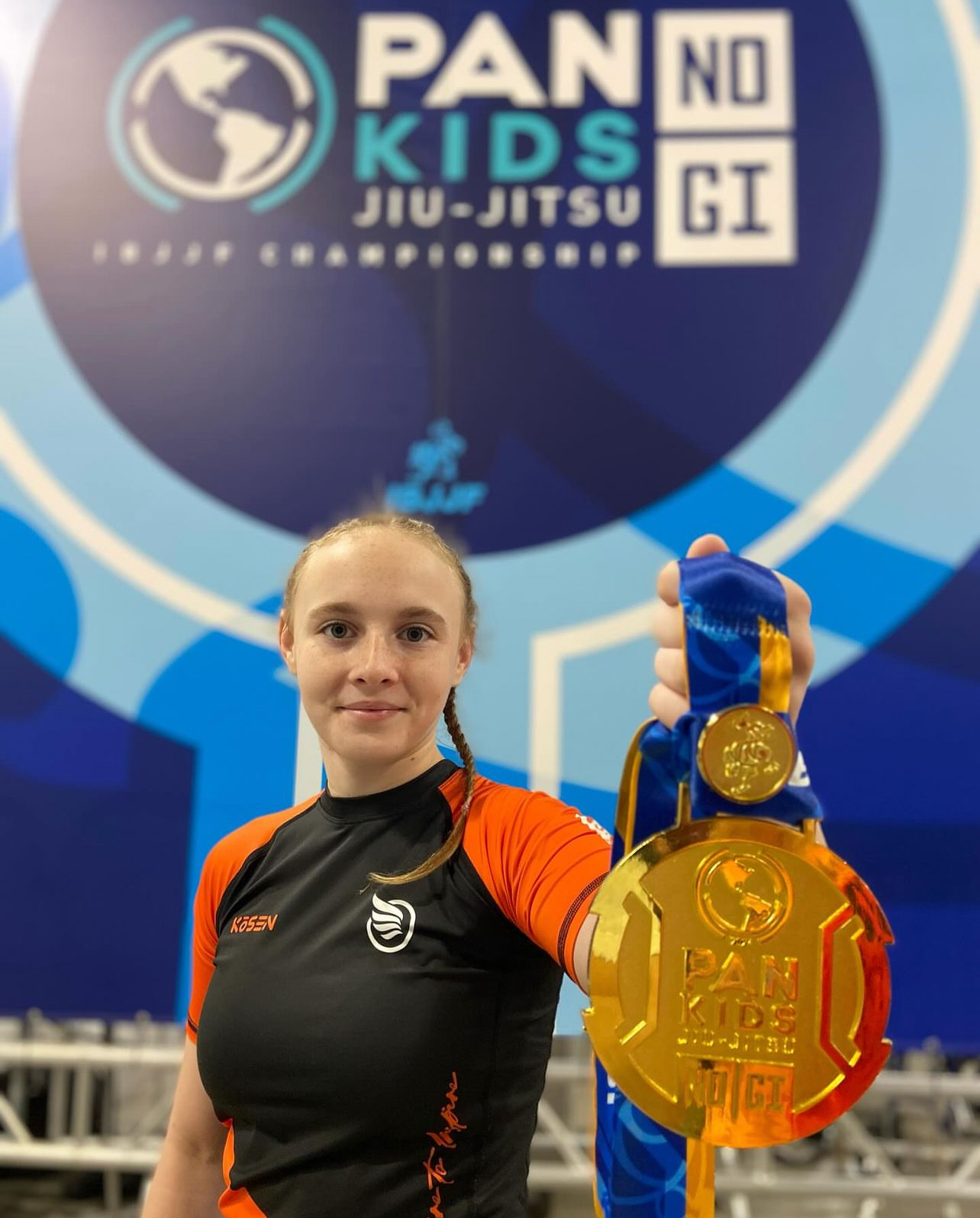 2024年 IBJJF Pan Kids No-Gi Championship で撮影された金メダルの写真。メダルには Pan Kids IBJJF Championship の表示がある。背景には PAN KIDS NO-GI IBJJF CHAMPIONSHIP の大会バックドロップが見える。